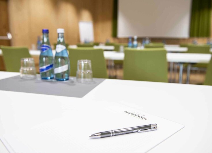 Tisch mit Schreibblock, Kugelschreiber und Wasserflaschen