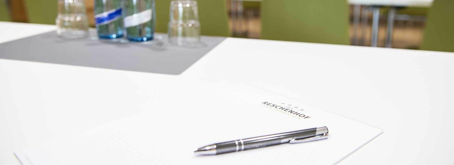 Tisch mit Schreibblock, Kugelschreiber und Wasserflaschen