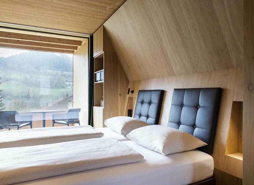 Bett in der Gartensuite Schlafbereich der Gartensuite mit Balkon und Ausblick