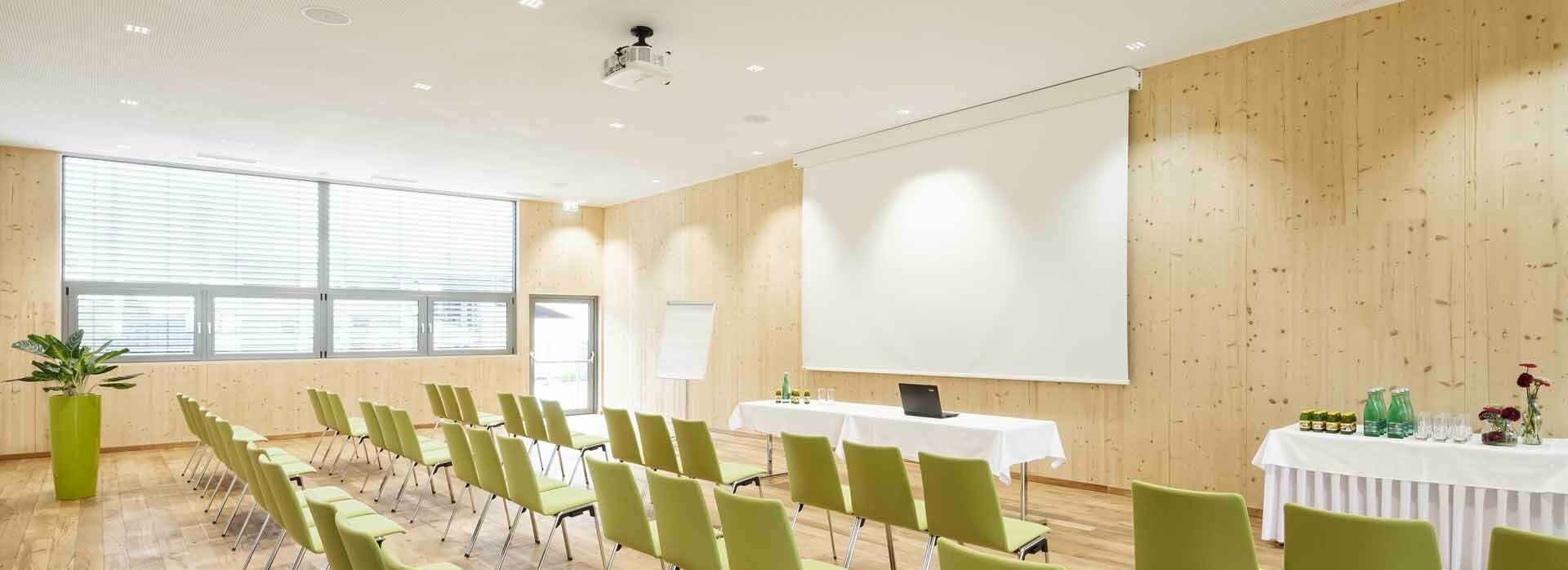 Seminarhotel in Mils in Tirol Seminarraum mit Stühlen, Leinwand, Beamer, Flipchart und Getränketisch
