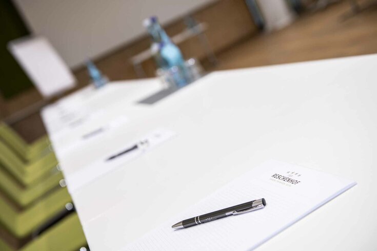 Seminar Tisch mit Schreibbedarf und Wasser in Seminarraum