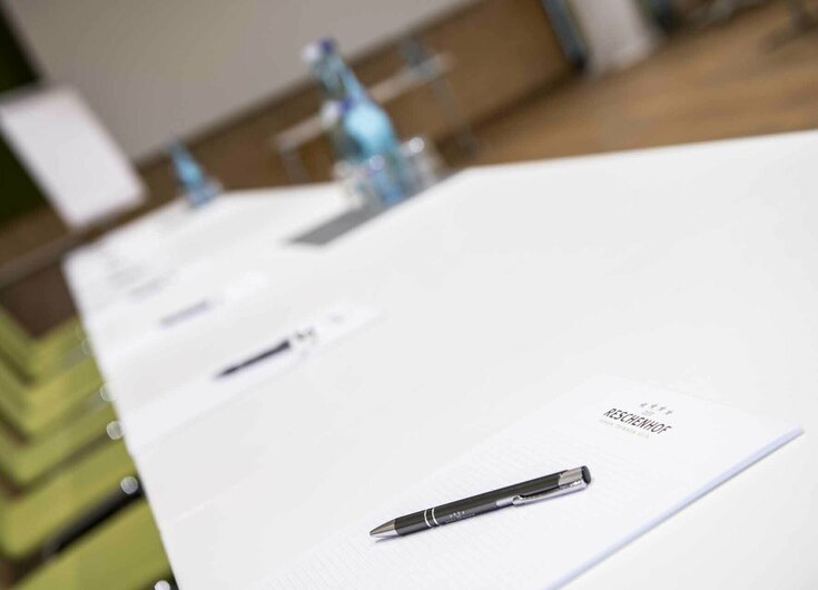 Seminar Tisch mit Schreibbedarf und Wasser in Seminarraum