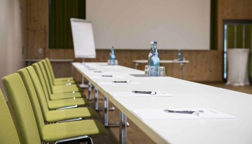 Seminare & Tagungen Tische mit Schreibbedarf und Wasser in Seminarraum