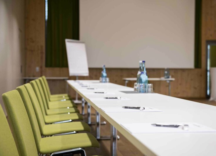 Tische mit Schreibbedarf und Wasser in Seminarraum